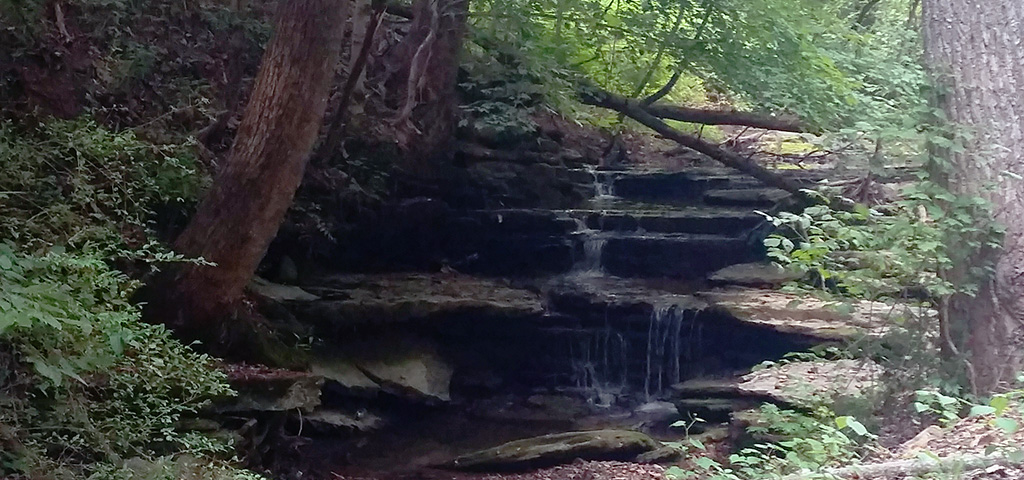 Small hidden waterfall from natural spring